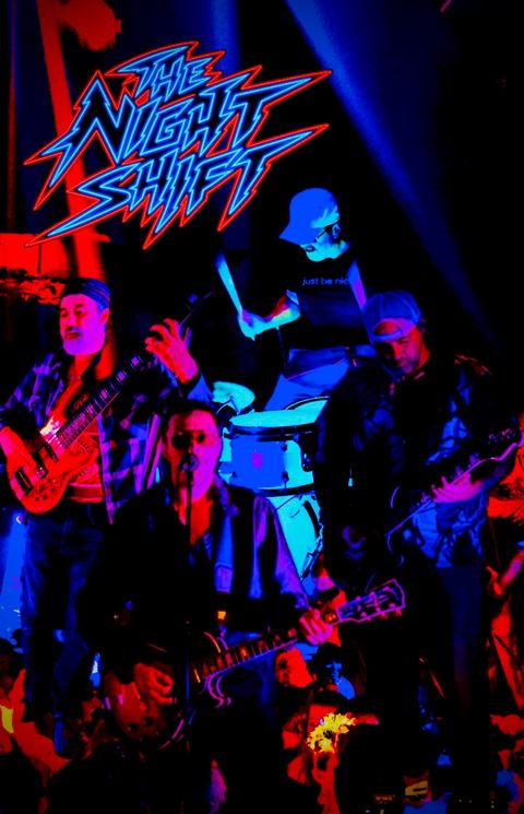 The Night Shift on stage in red and blue light, with the neon Night Shift logo above the band